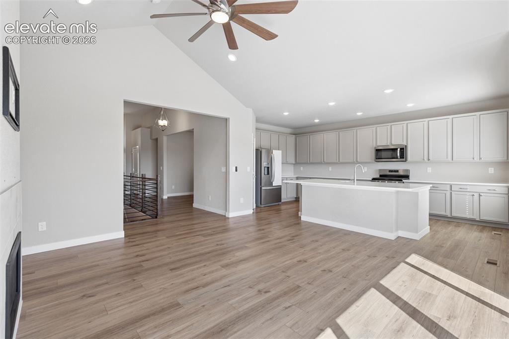 Image 8 of 40: Vaulted ceiling with an integrated ceiling fan, wood-finish flooring, reces