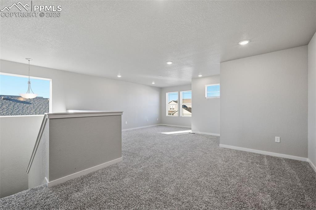 Image 18 of 48: Spare room with a textured ceiling, light carpet, and recessed lighting