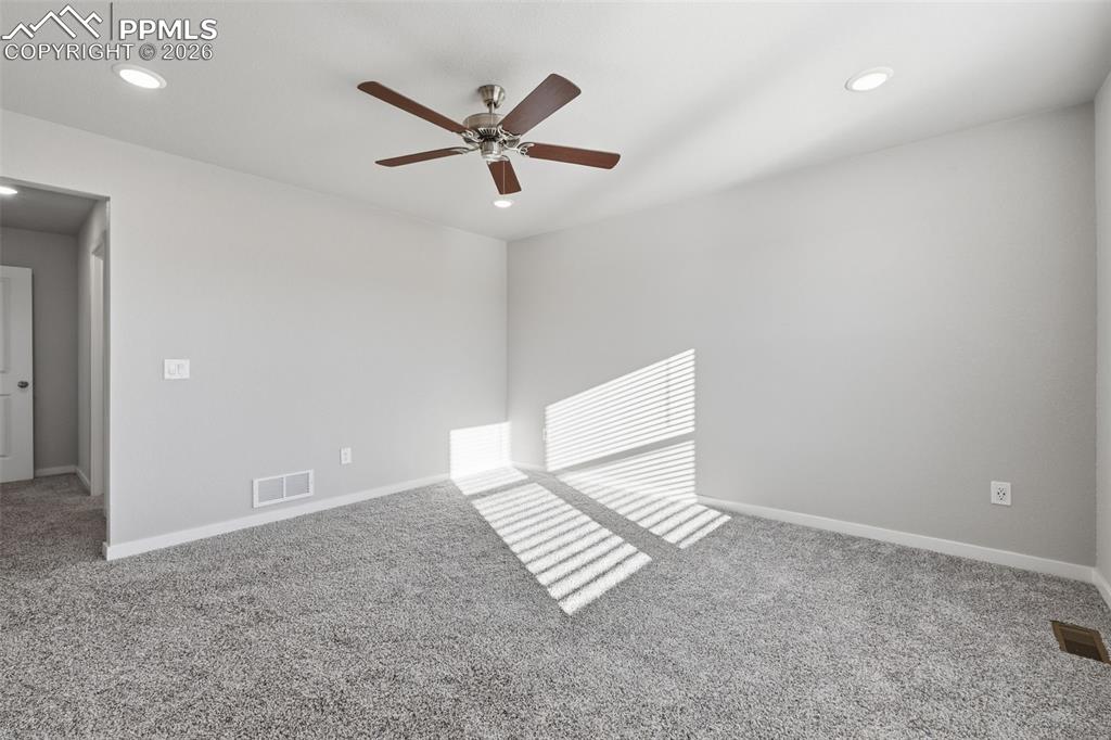 Image 25 of 48: Empty room with light carpet, a ceiling fan, and recessed lighting
