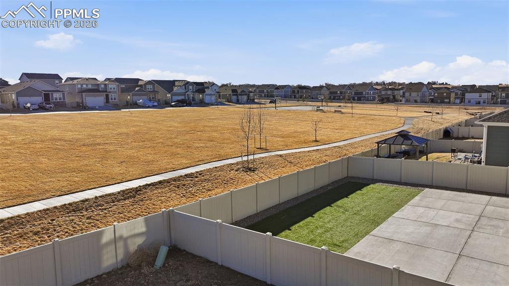 Image 44 of 48: Fenced backyard with a residential view