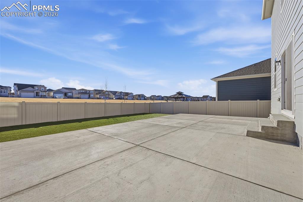 Image 46 of 48: Fenced backyard with a residential view and a patio