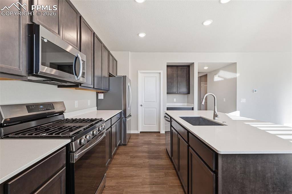 Image 8 of 48: Kitchen featuring stainless steel appliances, dark wood finish cabinetry, a