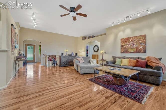 Image 12 of 48: Living room featuring arched walkways, light wood-style flooring, and ceili