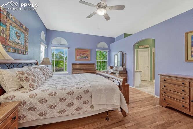 Image 27 of 48: Bedroom with wood floors and a ceiling fan