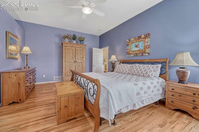 Image 28 of 48: Bedroom with wood floors and a ceiling fan