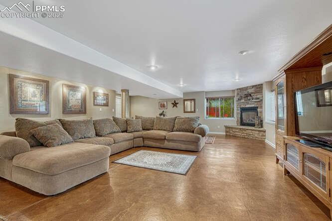 Image 32 of 48: Family room with a stone fireplace, walk-out