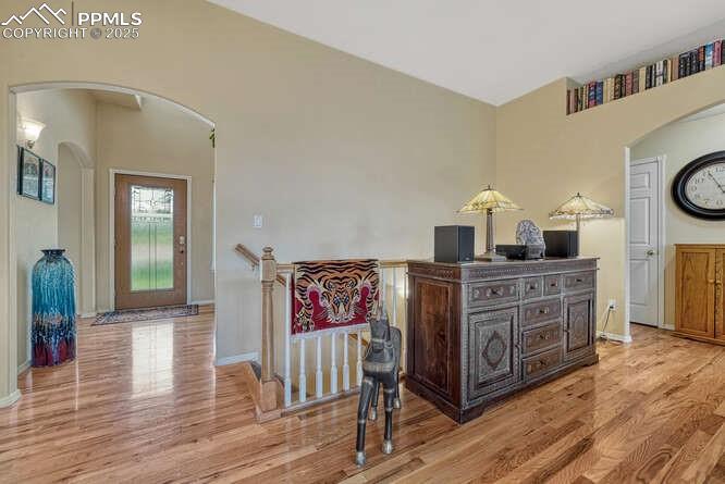 Image 4 of 48: Hall with arched walkways, wood floors