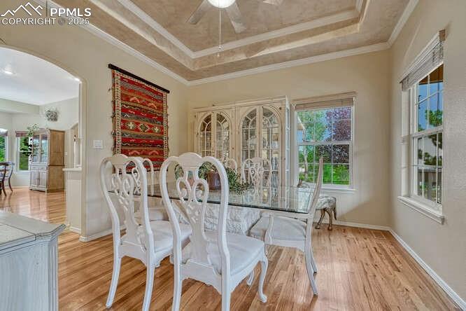 Image 8 of 48: Dining space with a tray ceiling, wood floors