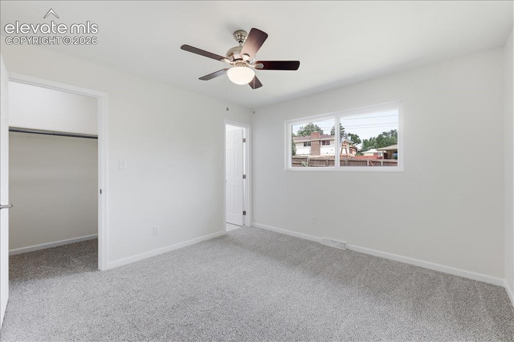 Image 15 of 44: Main level primary bedroom with walk-in closet and attached bathroom.