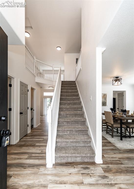 Image 28 of 50: Stairs with wood finished floors, baseboards, and recessed lighting