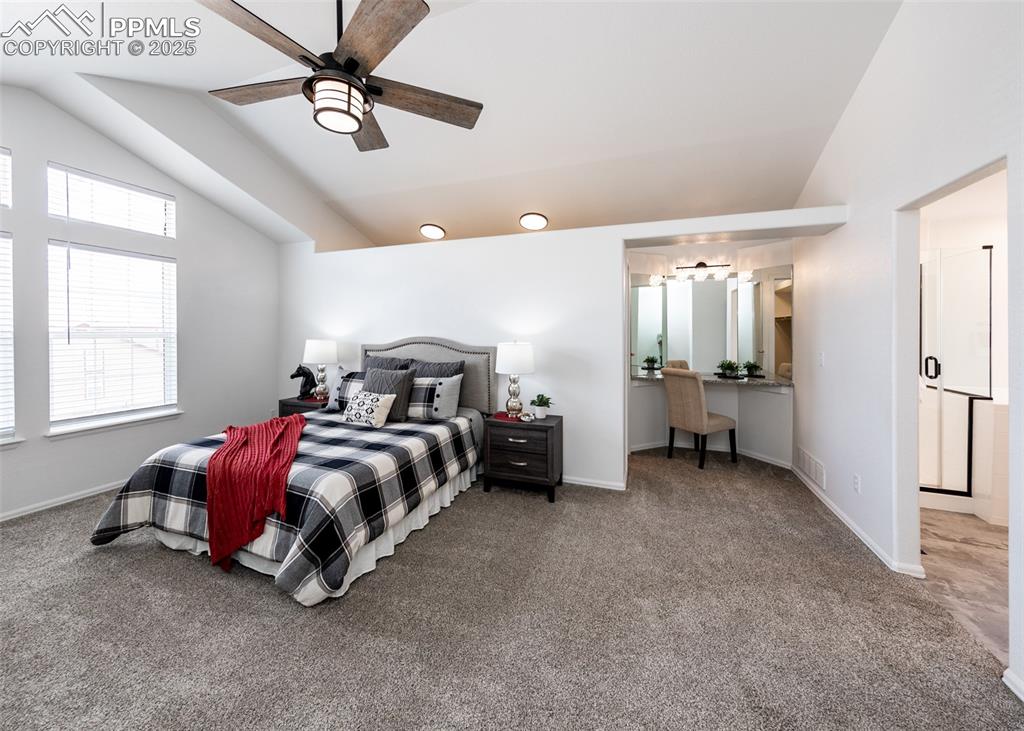 Image 33 of 50: Bedroom with lofted ceiling, carpet flooring, ceiling fan, and baseboards
