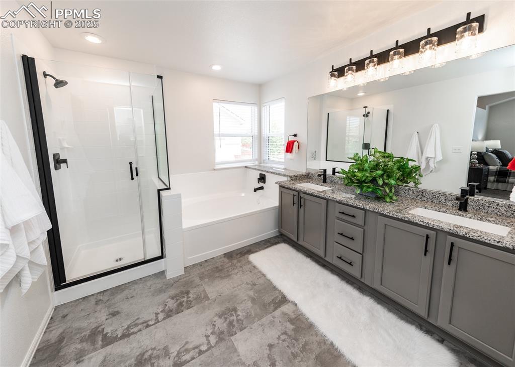 Image 36 of 50: Full bath with a garden tub, a shower stall, and double vanity