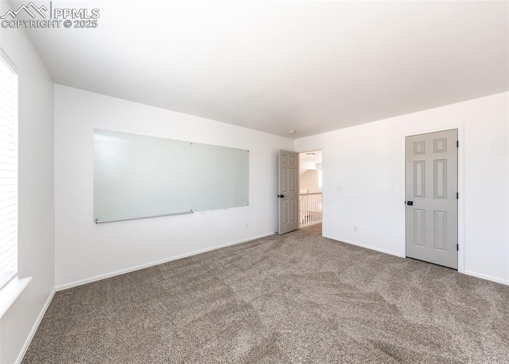 Image 40 of 50: Spare room with carpet flooring and baseboards