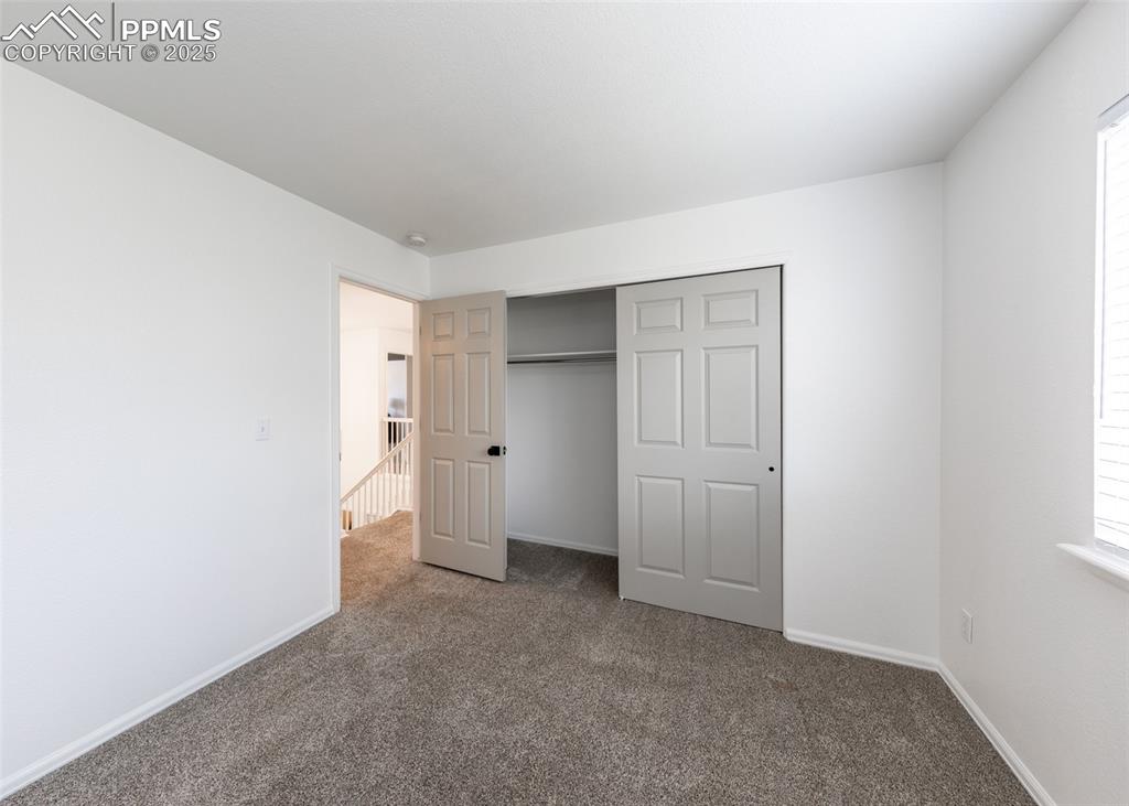Image 41 of 50: Unfurnished bedroom with carpet flooring, baseboards, and a closet