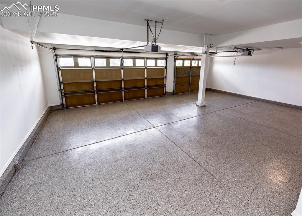 Image 46 of 50: Garage featuring baseboards and a garage door opener