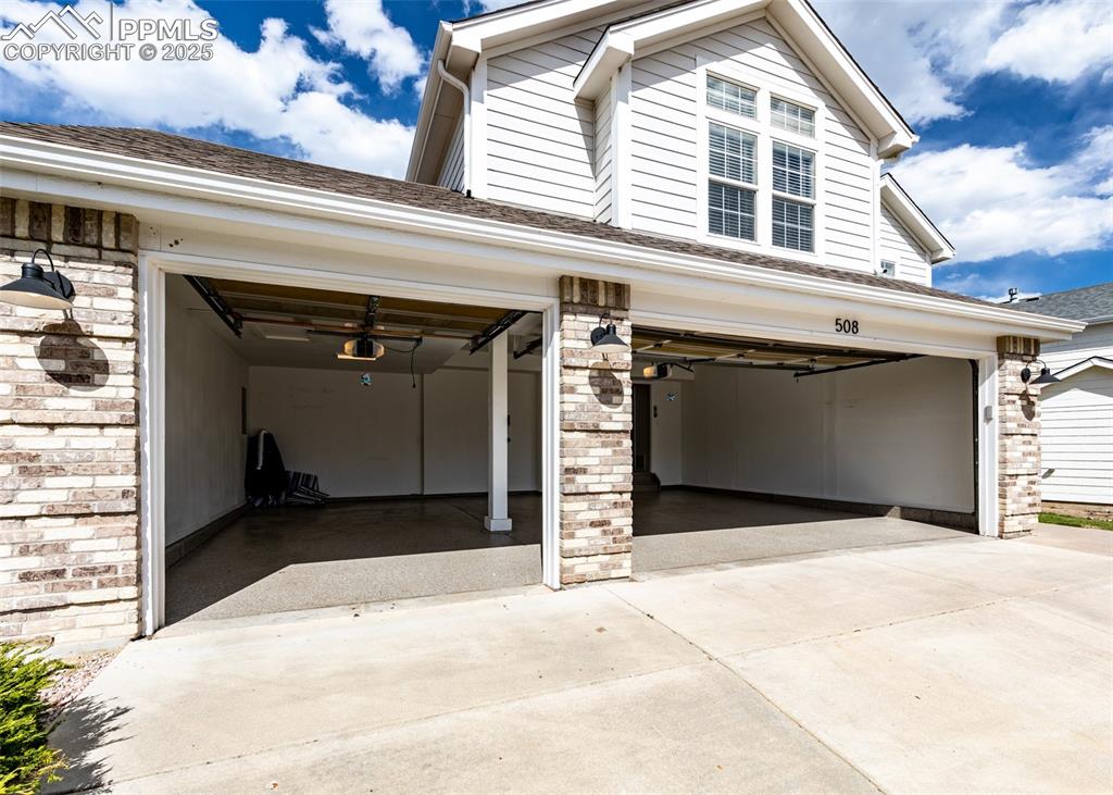 Image 47 of 50: Garage featuring driveway and a garage door opener