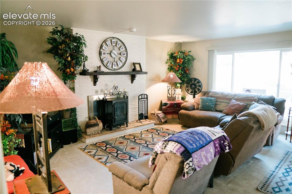 Image 15 of 23: White brick fireplace with dark wood mantle