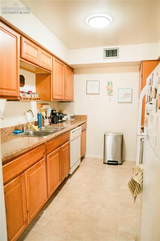 Image 2 of 23: Kitchen featuring wood cabinetry, light-toned countertops, a stainless stee