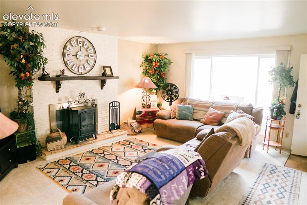 Image 20 of 23: White painted brick fireplace with a dark wood mantel and a wood-burning st