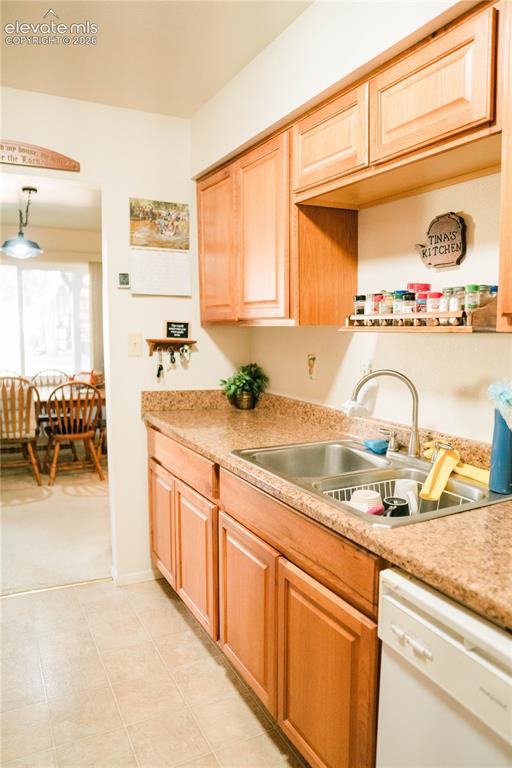Image 21 of 23: Kitchen featuring wood-finish cabinetry, a double basin stainless steel sin