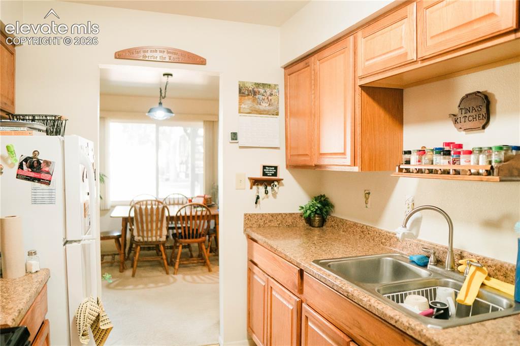 Image 5 of 23: Wood-finish cabinetry paired with a dual basin stainless steel sink and gra