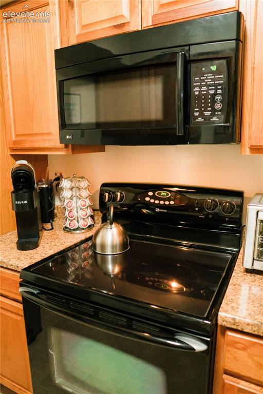 Image 7 of 23: Built-in black microwave, black electric range with an oven, granite-finish