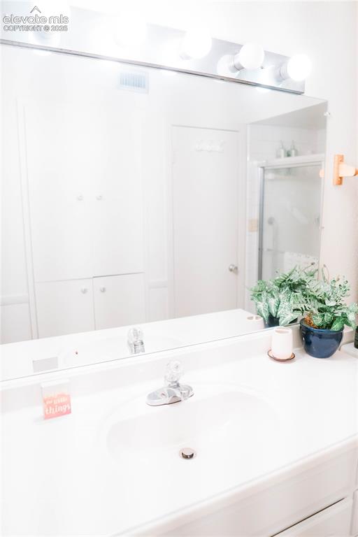 Image 9 of 23: Vanity with an integrated sink, polished chrome faucet, and a large wall-mo
