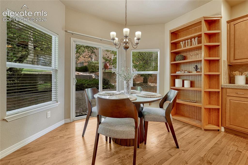 Image 13 of 42: The eat-in kitchen features hardwood flooring and a walk-out...