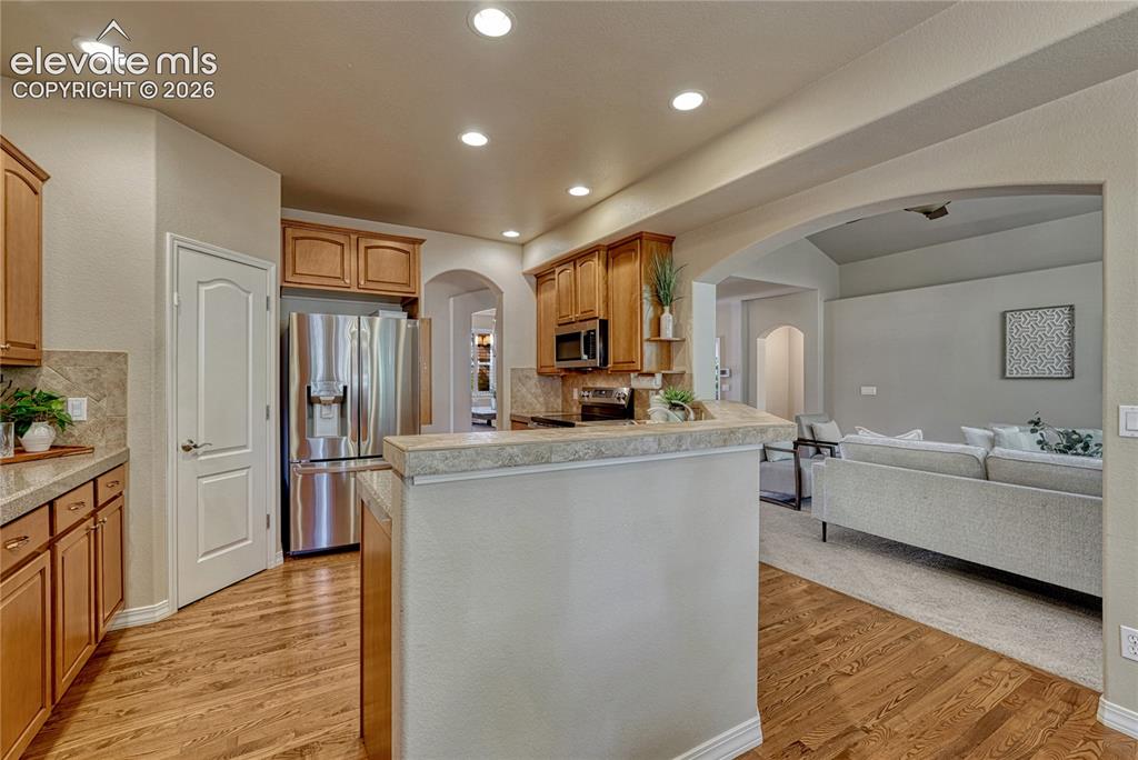 Image 18 of 42: Kitchen has hardwood floors, stainless steel appliances...