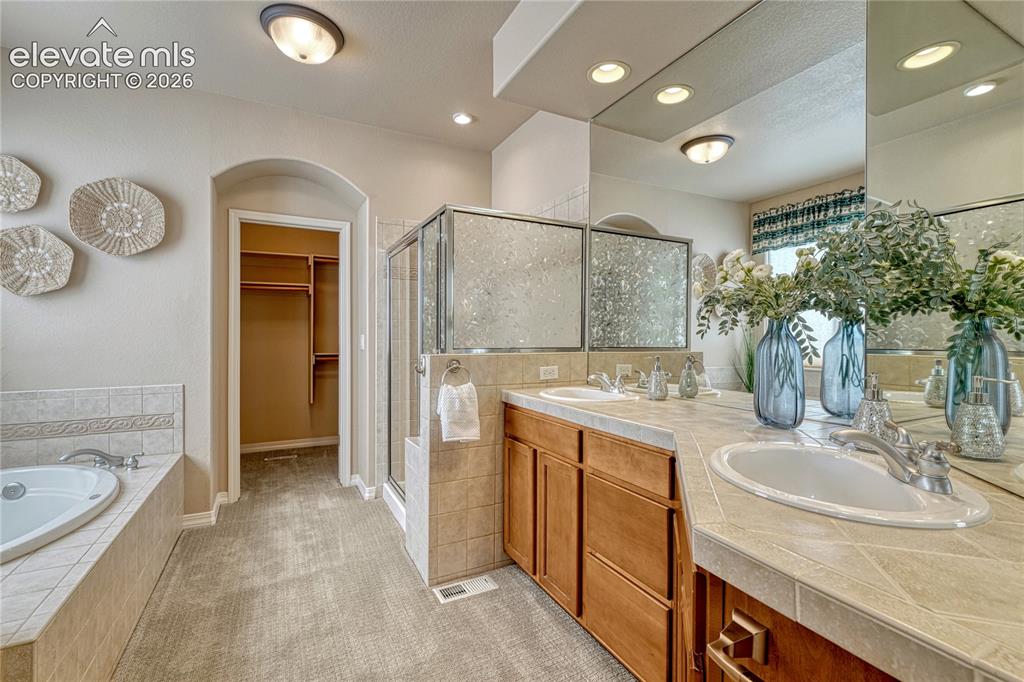 Image 24 of 42: Adjoining 5-piece bathroom with walk-in closet.
