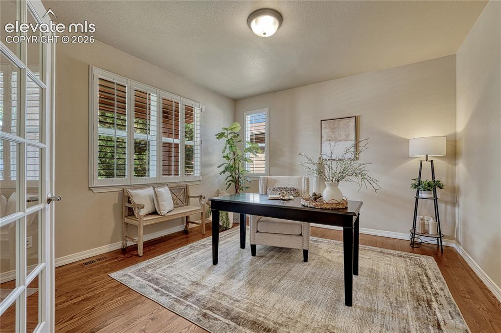 Image 8 of 42: Also adjacent to the foyer is the main level office with hardwood floor...