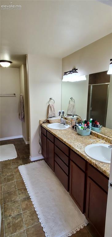 Image 11 of 20: Dual vanity with undermount sinks, stone-finish countertop, dark wood-finis