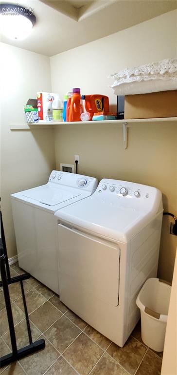 Image 12 of 20: Laundry area featuring tiled flooring, a built-in white shelf, and an overh