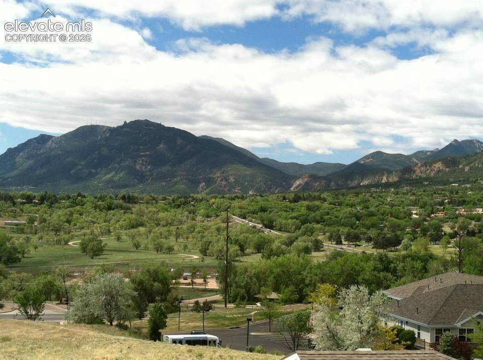 Image 17 of 20: Mountain backdrop, expansive treed landscape, distant buildings