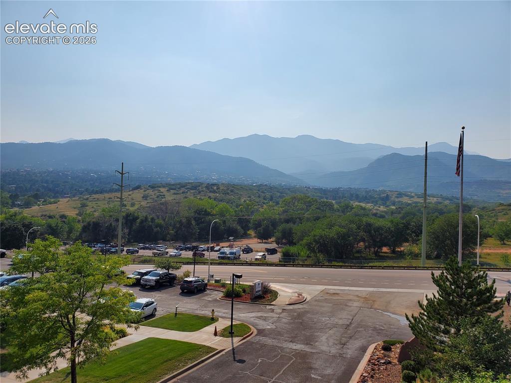 Image 19 of 20: Expansive mountain backdrop with distant hills and lush green trees