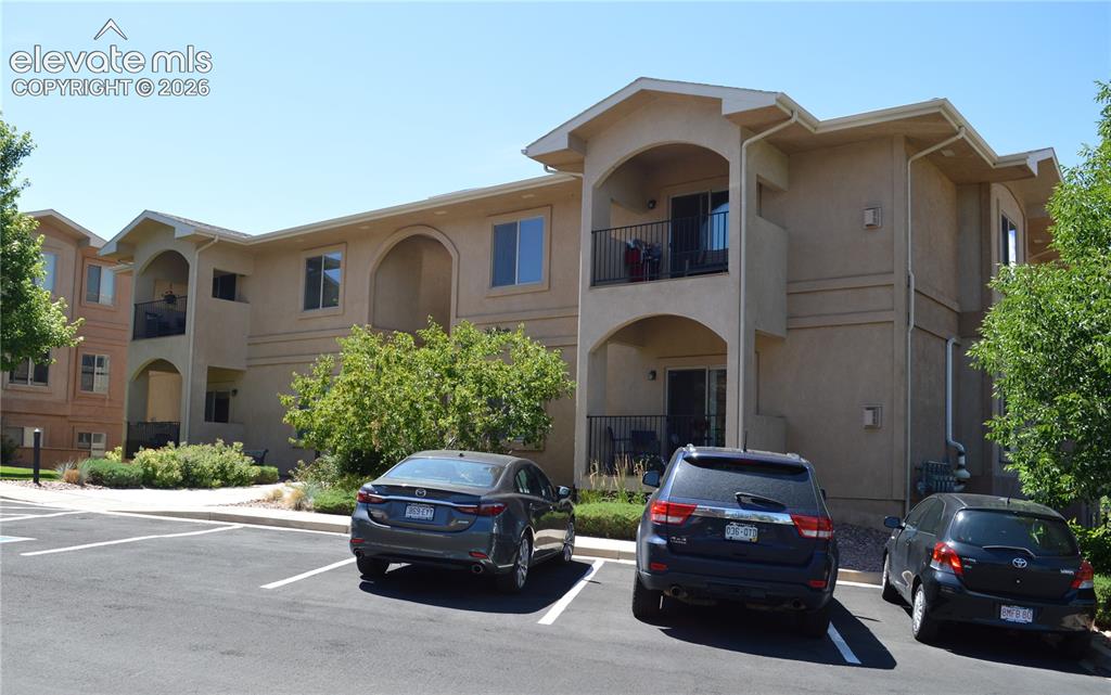 Image 2 of 20: Multi-story stucco exterior featuring balconies with black railings, arched