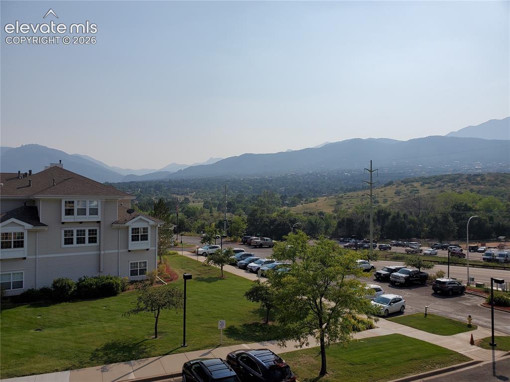 Image 20 of 20: Expansive mountain backdrop with a multi-story residential building, manicu