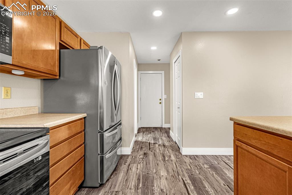 Image 11 of 28: Kitchen featuring wood finish cabinetry, light countertops, stainless steel