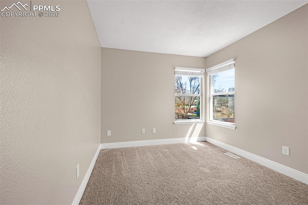 Image 12 of 28: Carpeted empty room featuring baseboards and a textured wall