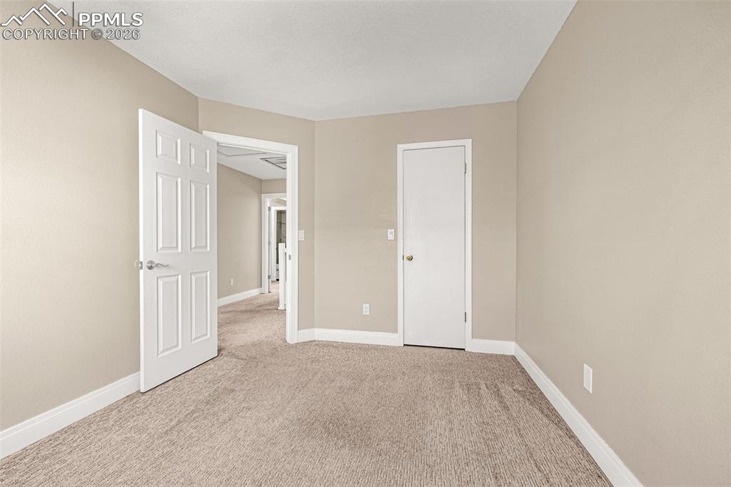 Image 14 of 28: Unfurnished bedroom with baseboards and light colored carpet
