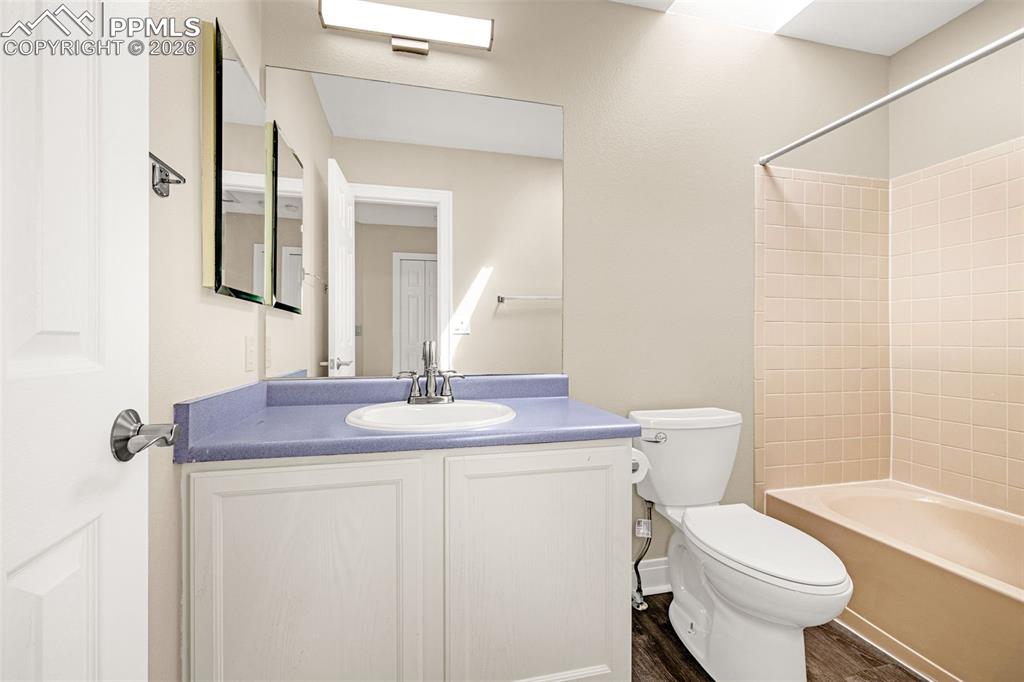 Image 16 of 28: Full bathroom featuring vanity, tub / shower combination, and dark wood fin