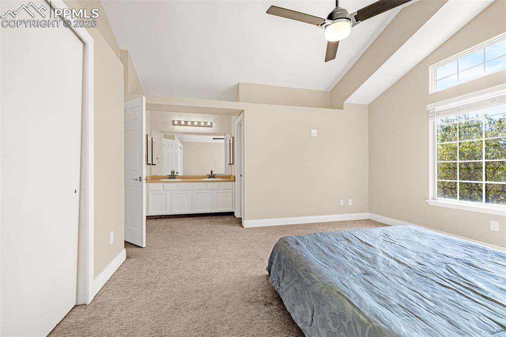 Image 18 of 28: Bedroom featuring light colored carpet, a ceiling fan, and lofted ceiling