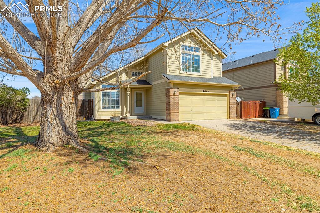 Image 2 of 28: View of front facade with an attached garage, brick siding, and driveway