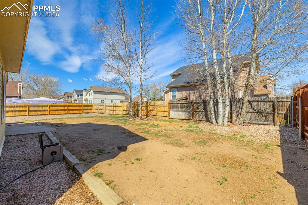 Image 28 of 28: Fenced backyard with a residential view