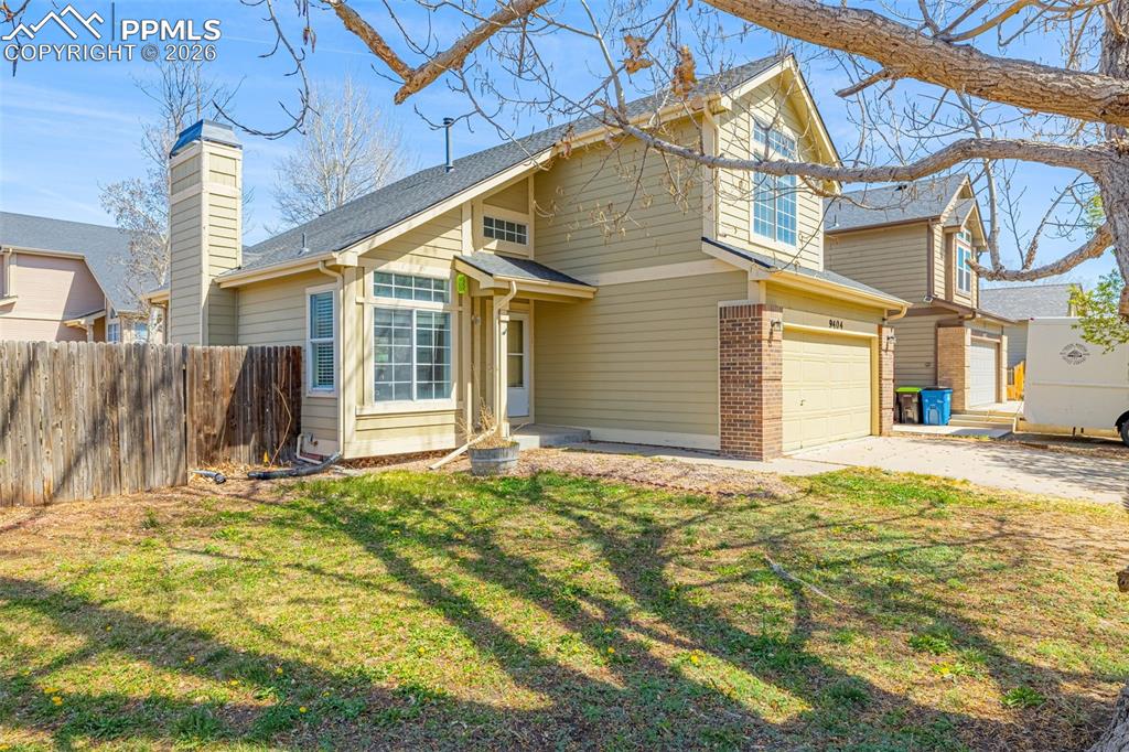 Image 3 of 28: Traditional home featuring driveway, a chimney, and an attached garage
