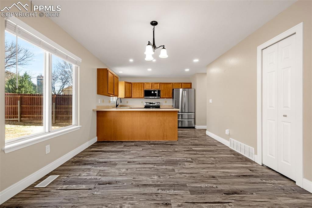 Image 7 of 28: Kitchen with light countertops, wood finish cabinetry, a peninsula, stainle