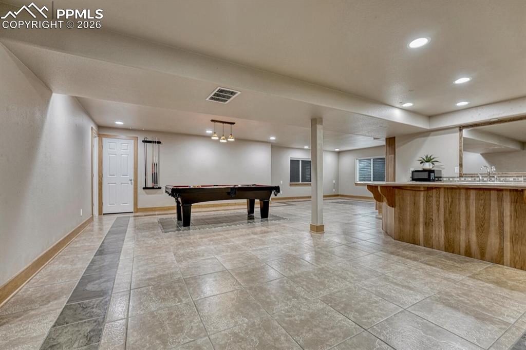 Image 28 of 50: Full Hall Bathroom with vanity, dreamed mirror, and tiled tub/shower.