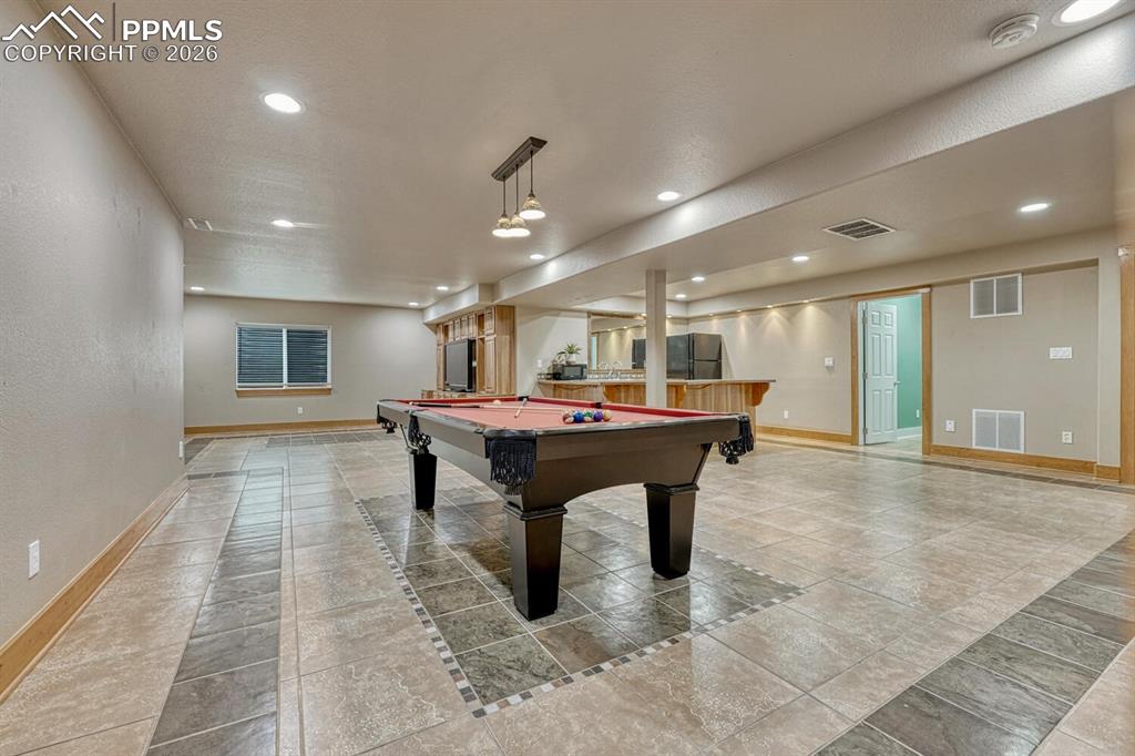 Image 29 of 50: Main Level Bedroom #3 with neutral carpet and a lighted ceiling fan.