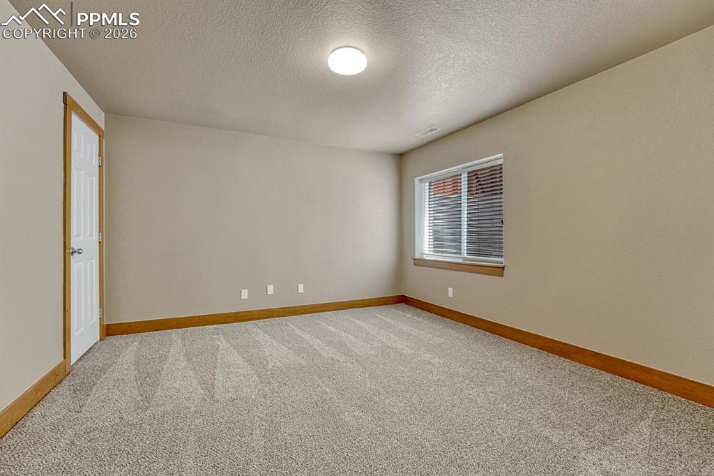 Image 37 of 50: Basement Flex Room with upper and lower cabinets. Central Vac location.