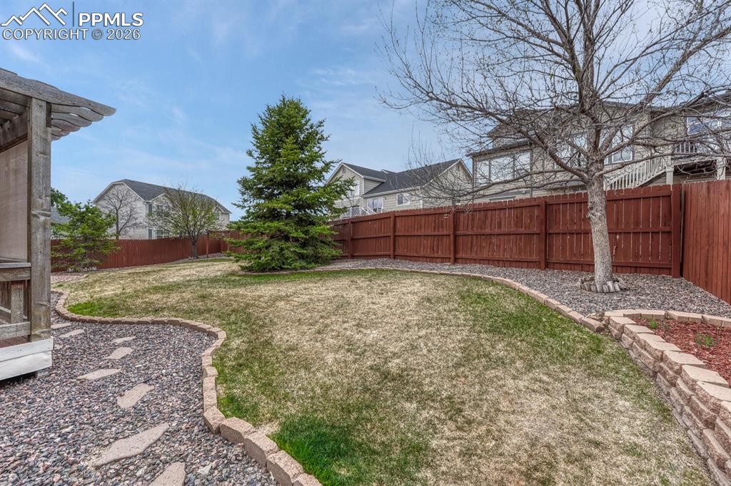Image 47 of 50: Backyard deck with covered pergola.